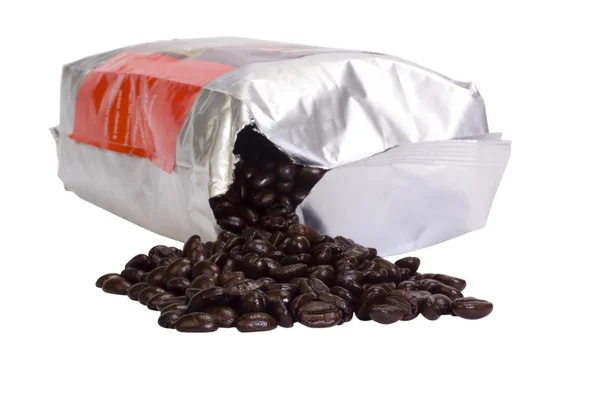 Kávová zrna rozlévají z paketu — Stock fotografie