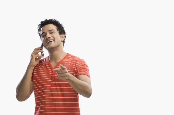 Hombre hablando en un teléfono móvil y señalando — Foto de Stock