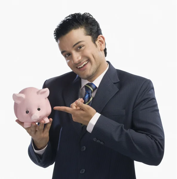 Zakenman wijzend op een piggy bank — Stockfoto