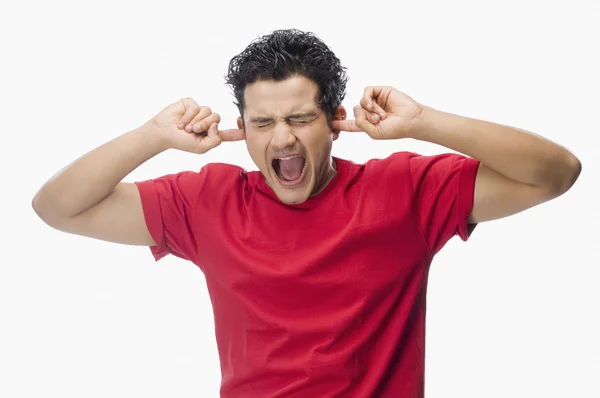 Man screaming with his fingers in ears — Stock Photo, Image