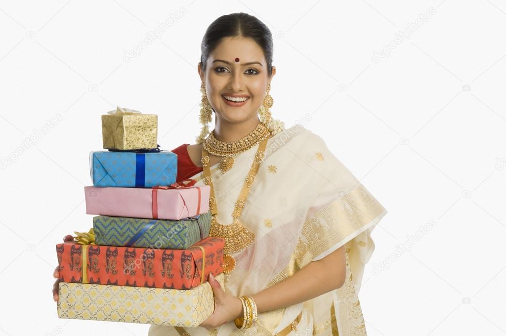 Woman holding gifts and smiling