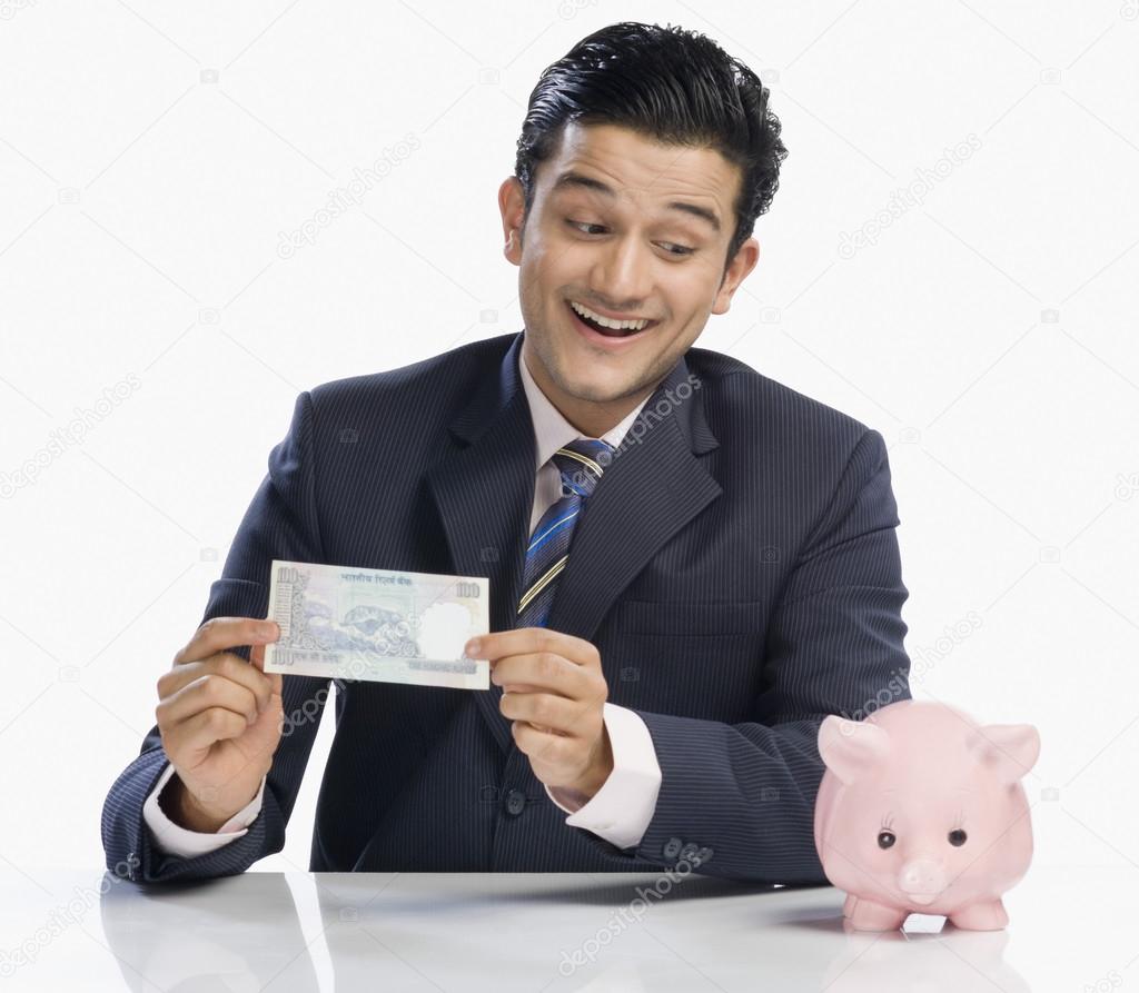 Businessman holding a currency note