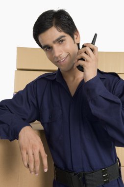 Store manager talking on a walkie-talkie in a warehouse clipart