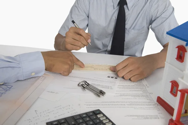 Immobilienmakler diskutiert ein Dokument mit einem Kunden — Stockfoto