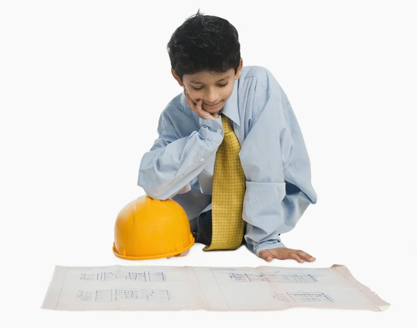 Pojke klädd som en arkitekt och arbetar på en plan — Stockfoto
