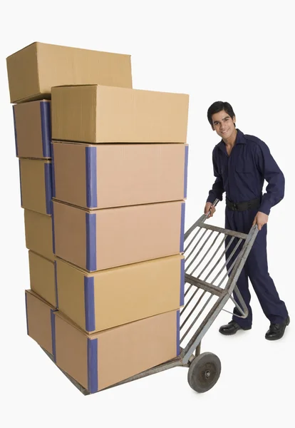 Storekeeper carrying cardboard boxes on a hand truck — Stock Photo, Image