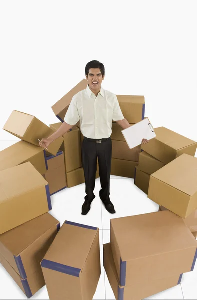 Store manager standing among cardboard boxes — Stock Photo, Image