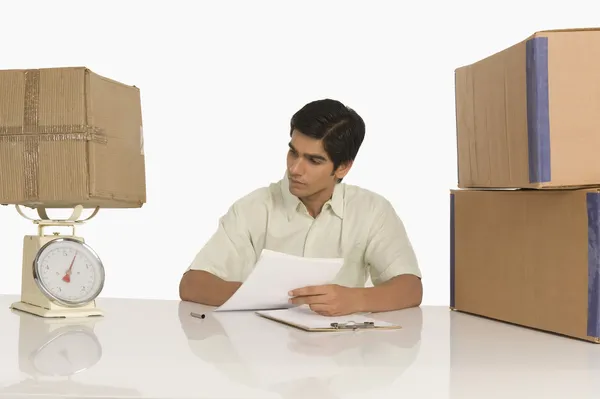 Store manager weighing a package on a weight scale — Stock Photo, Image