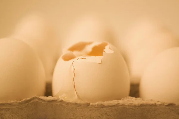 Huevo roto en una caja con otros huevos — Foto de Stock