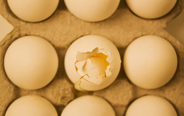 Uovo rotto in una scatola con altre uova — Foto Stock
