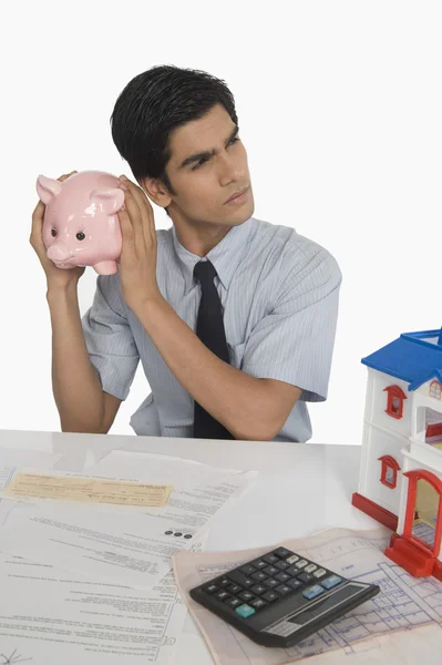 Real estate agent holding a piggy bank — Stock Photo, Image