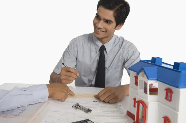 Immobilienmakler diskutiert ein Dokument mit einem Kunden — Stockfoto