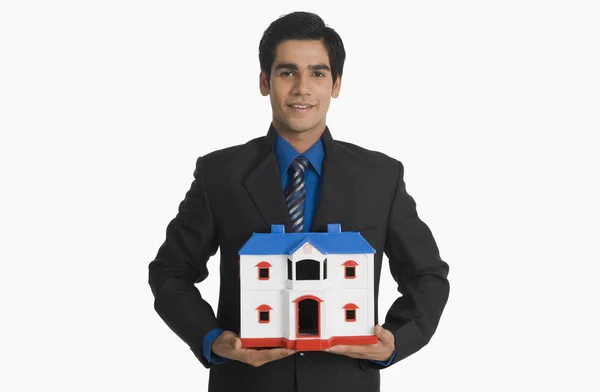Agente imobiliário segurando uma casa modelo — Fotografia de Stock