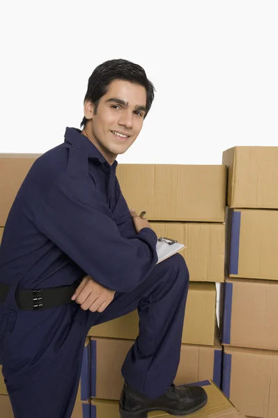 Store manager standing near cardboard boxes — Stock Photo, Image