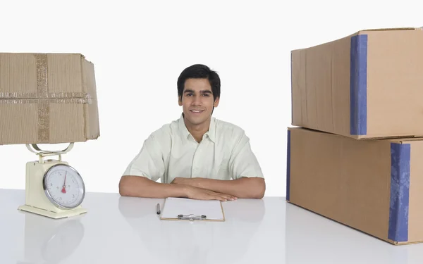 Store manager at desk with a weight scale — Stock Photo, Image