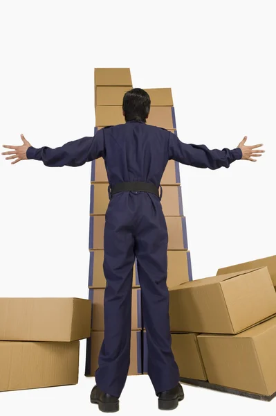 Store manager looking at a stack of cardboard boxes — Stock Photo, Image