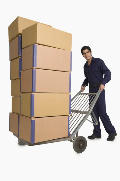 Storekeeper carrying cardboard boxes on a hand truck — Stock Photo, Image