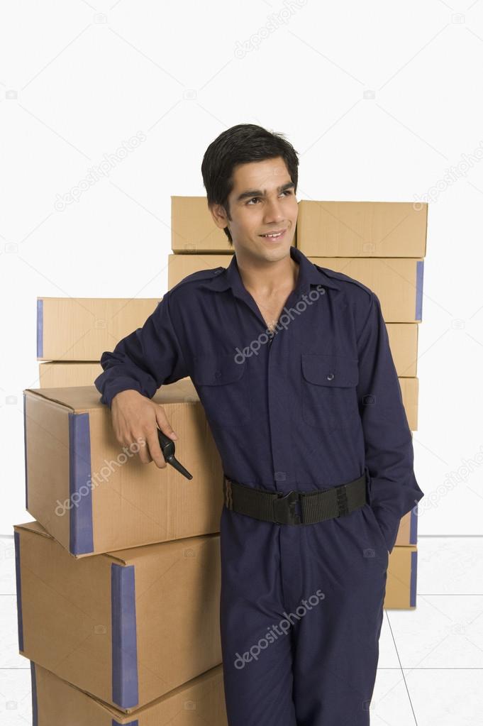 Store manager leaning against cardboard boxes