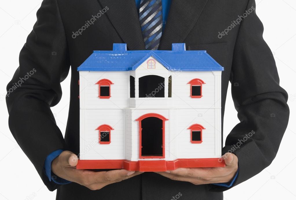Real estate agent holding a model home