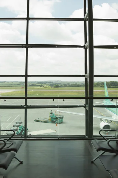 Flugzeug durch ein Flughafen-Lounge-Fenster betrachtet — Stockfoto