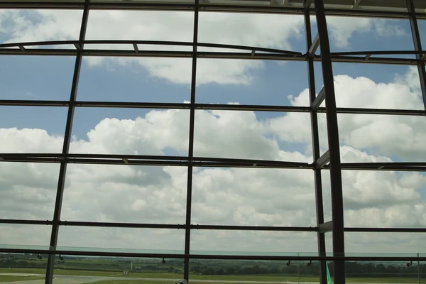 Wolken weergegeven via een luchthaven lounge venster — Stockfoto