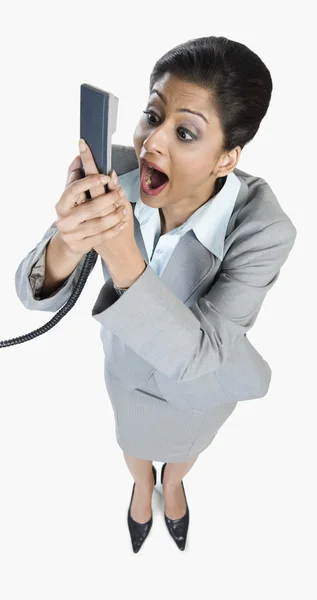 Mujer de negocios gritando en un receptor de teléfono — Foto de Stock