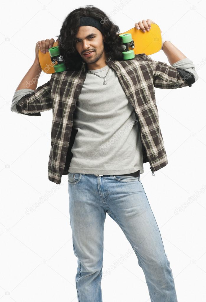 Man holding a skateboard on his shoulders