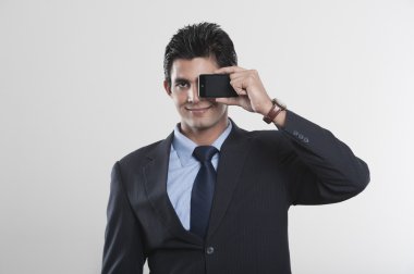 Elinde cep telefonu olan bir iş adamı.