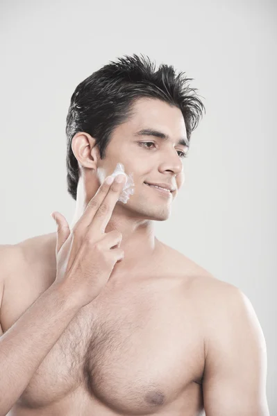 Man applying moisturizer on his face — Stock Photo, Image