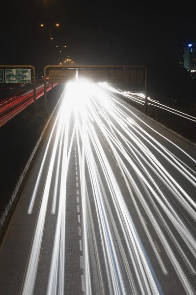 Streaks of headlights of moving vehicles on the road — Stock Photo, Image