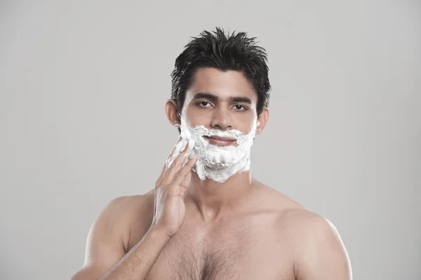 Uomo che applica la crema da barba sul viso — Foto Stock