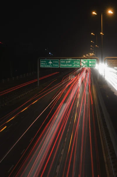 Streaks of headlights of moving vehicles on the road — Stock Photo, Image