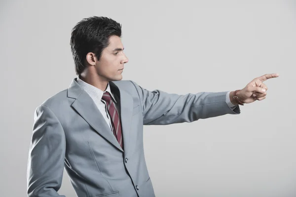 Businessman pointing away with finger — Stock Photo, Image