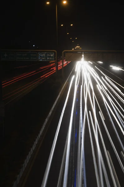 Streaks of headlights of moving vehicles on the road — Stock Photo, Image