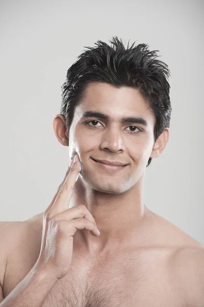 Man applying moisturizer on his face — Stock Photo, Image