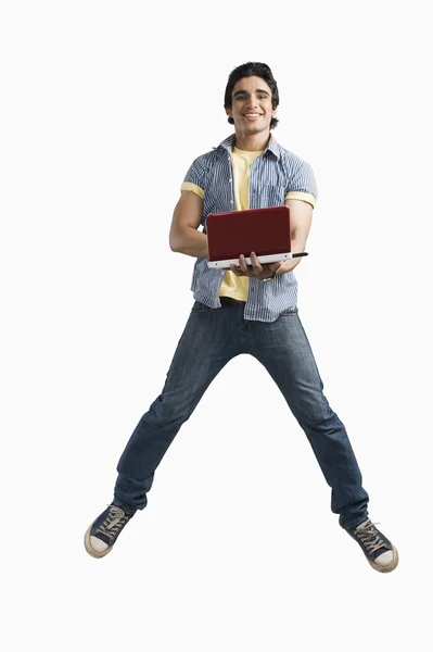 Man working on a laptop and jumping — Stock Photo, Image