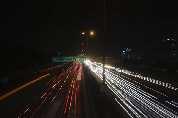 Streaks of headlights of moving vehicles on the road — Stock Photo, Image