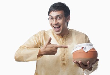 Bengali man pointing towards a pot of rasgulla clipart
