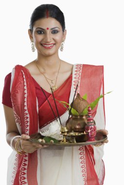 Bengali woman holding a puja thali clipart