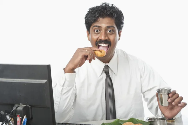 Empresário trabalhando em um escritório e tendo comida — Fotografia de Stock