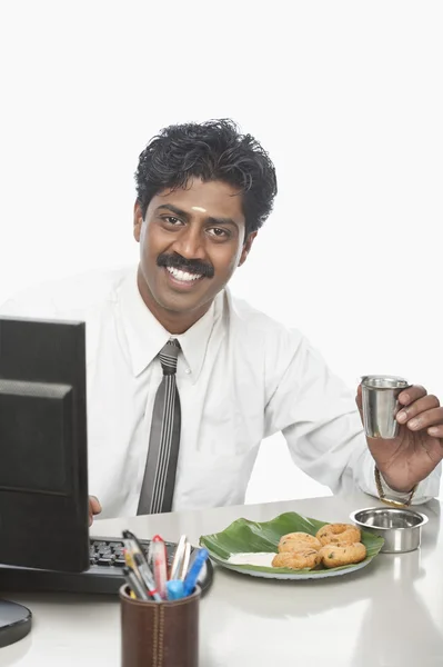 Επιχειρηματίας που εργάζεται σε ένα γραφείο και έχοντας τροφίμων — Φωτογραφία Αρχείου