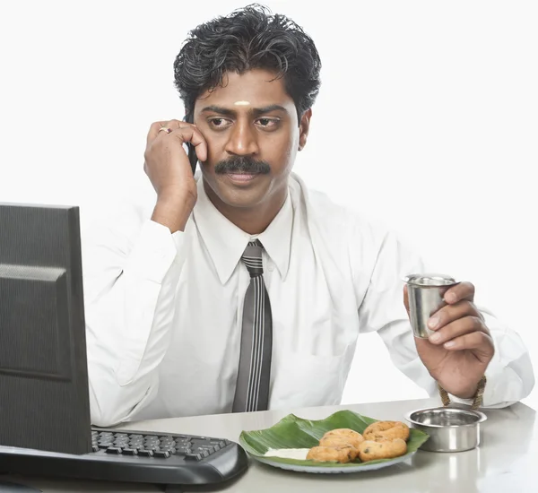 Geschäftsmann arbeitet im Büro und isst — Stockfoto