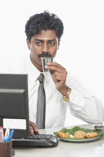 Empresario trabajando en una oficina y comiendo — Foto de Stock