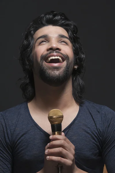 Cantor segurando um microfone e cantando — Fotografia de Stock