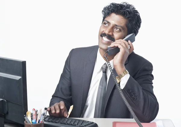 Empresário usando um computador e um telefone — Fotografia de Stock