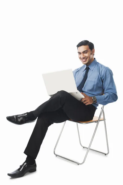 Homme d'affaires bengali utilisant un ordinateur portable sur une chaise — Photo