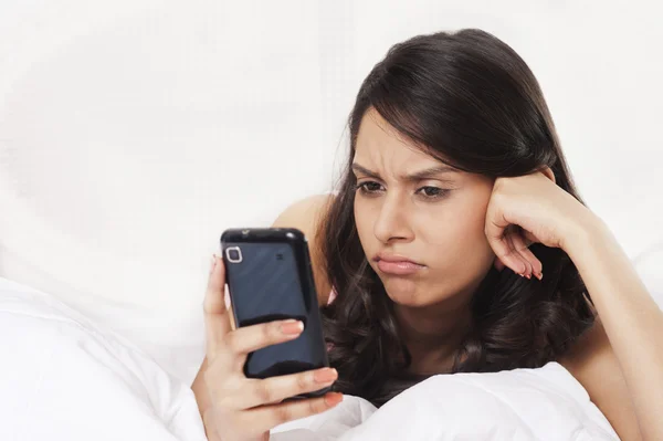 Kvinna textmeddelanden på en mobiltelefon — Stockfoto