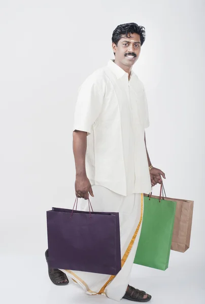 Muž nesoucí nákupní tašky — Stock fotografie