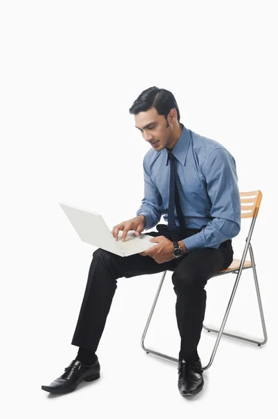 Bengali businessman using a laptop on a chair — Stock Photo, Image