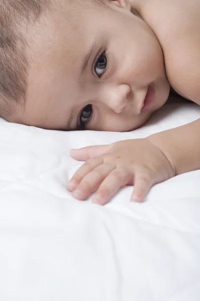 Pojken ligger på sängen. — Stockfoto